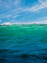 Crashing wave in ocean. Breaking turquoise wave with sun light and blue sky