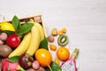 Crate and different exotic fruits on white wooden table, flat lay. Space for text Royalty Free Stock Photo