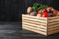 Crate full of different vegetables and fruits on black wooden table, space for text. Harvesting time Royalty Free Stock Photo