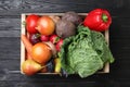 Crate full of different vegetables and fruits on black wooden table, top view. Harvesting time Royalty Free Stock Photo