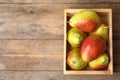 Crate with ripe juicy pears on brown  table, flat lay. Space for text Royalty Free Stock Photo