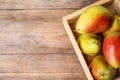 Crate with ripe juicy pears on brown wooden table. Space for text Royalty Free Stock Photo