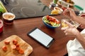 Crave The Taste. Close up of process of cooking. Woman preparing healthy meal in the kitchen checking recipe using Royalty Free Stock Photo