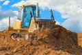 Crawler bulldozer - excavator with clipping path on a background with blue sky and clouds. work on construction site or sand pit Royalty Free Stock Photo