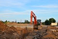 Crawler excavator in construction site on the background of tower cranes and multi-storey residential buildings Royalty Free Stock Photo