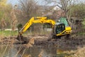 Crawler excavator or digger dredges on the lake Royalty Free Stock Photo