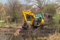 Crawler excavator or digger dredges on the lake Royalty Free Stock Photo