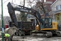 A crawler excavator digs dirt next to a dump truck in Chicago