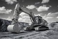 Crawler excavator at earthmoving works in black and white