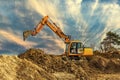 Crawler excavator during earthmoving works on construction site at sunset Royalty Free Stock Photo