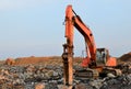 Crawler excavator with hydraulic hammer for the destruction of concrete and hard rock at the construction site. Salvaging and Royalty Free Stock Photo