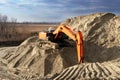 crawler excavator in the rays of the setting sun at sunset digs earth and sand at a construction site for the construction of the Royalty Free Stock Photo