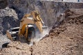 Yellow excavator is filling a dump truck with rocks at coal mines Royalty Free Stock Photo