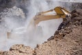 Yellow excavator is filling a dump truck with rocks at coal mines Royalty Free Stock Photo