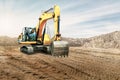 Crawler excavator works in a sand pit against the sky. Powerful earthmoving equipment. Excavation. Construction site. Rental of Royalty Free Stock Photo