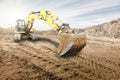 Crawler excavator works in a sand pit against the sky. Powerful earthmoving equipment. Excavation. Construction site. Rental of Royalty Free Stock Photo