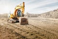 Crawler excavator works in a sand pit against the sky. Powerful earthmoving equipment. Excavation. Construction site. Rental of Royalty Free Stock Photo