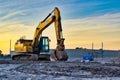 Crawling Excavator digger on construction site at sunset. Royalty Free Stock Photo