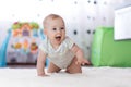 Crawling funny baby boy indoors at home