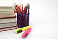 Crayon or colored pencils in box with side stack of books and school supplies. Concept of learning and study. Royalty Free Stock Photo