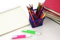 Crayon or colored pencils in box with side stack of books and school supplies on with background. Royalty Free Stock Photo