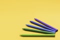 Crayons of complementary colors on a bright yellow background Royalty Free Stock Photo
