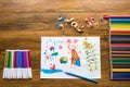 Crayons, felt-tip pens and a child`s drawing Royalty Free Stock Photo