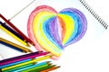 Crayons and heart on notebook