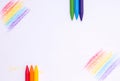 Crayons on a painted sheet of white paper. Copy space Royalty Free Stock Photo