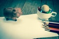 Crayons and piggy bank on a sheet of paper,vintage effect filter Royalty Free Stock Photo
