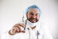 Crazy bearded doctor in a white coat and old syringe