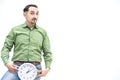 Crazy bearded man in green shirt with funny face expression, holding clock, isolated on white background. Royalty Free Stock Photo