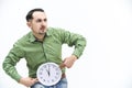 Crazy bearded man in green shirt with funny face expression, holding clock, isolated on white background. Royalty Free Stock Photo