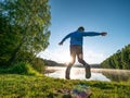 Crazy boy is making fun and jumping on lake bank Royalty Free Stock Photo