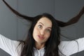 Crazy brunette woman makes grimaces on gray background