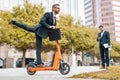 Crazy business, fast and easy. Funny excited business man in a suit riding an scooter on a business meeting. Businessman