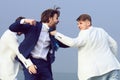 Crazy business man fighting. Young people fighting in nature on blue sky background. Royalty Free Stock Photo
