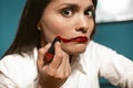 Crazy business woman with red lipstick doing makeup at work. Female mouth. Beautiful woman face. Close up portrait Royalty Free Stock Photo