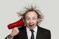 Crazy businessman with loudspeaker on white background, studio portrait