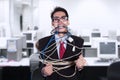 Crazy businessman tied in cable and rope at office Royalty Free Stock Photo