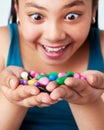 Crazy for candy. Studio shot of a cute young girl holding a handful of colorful jelly beans. Royalty Free Stock Photo