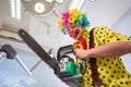 Crazy clown with chainsaw in dental clinic