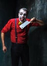 The crazy clown holding a knife on dack. Halloween concept Royalty Free Stock Photo