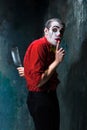 The crazy clown holding a knife on dack. Halloween concept Royalty Free Stock Photo