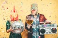 Crazy couple celebrating new year eve wearing chicken and dinosaur t-rex mask - Young trendy people having fun drinking champagne Royalty Free Stock Photo