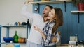 Joyful couple have fun dancing and singing in the kitchen at home in the morning Royalty Free Stock Photo