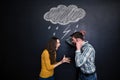 Crazy couple yelling under drawn raincloud over blackboard background