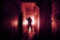 Crazy criminal killer or robber or rapist with knife in hand in dark scary corridor, horror and thriller atmosphere, red toned