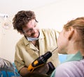 Crazy dentist treats teeth of the unfortunate patient. The patient is terrified. Royalty Free Stock Photo