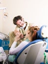 Crazy dentist treats teeth of the unfortunate patient. The patient is terrified. Royalty Free Stock Photo